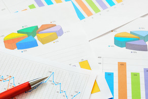 Bunte Kreis- und Balkendiagramme und ein Graph im Detail auf verschiedenen Seiten, die übereinander liegen. 